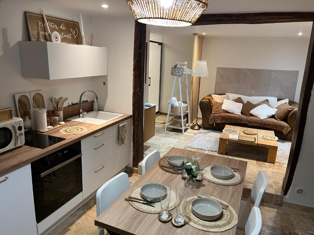 a kitchen and living room with a table and a couch at Le domaine des amours in Saint-Josse
