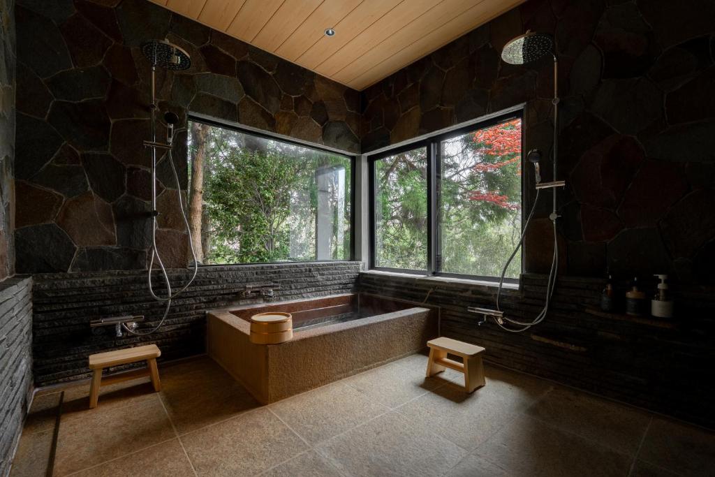 a large bathroom with a large tub and a window at MUSUBI Hakone in Sengokuhara