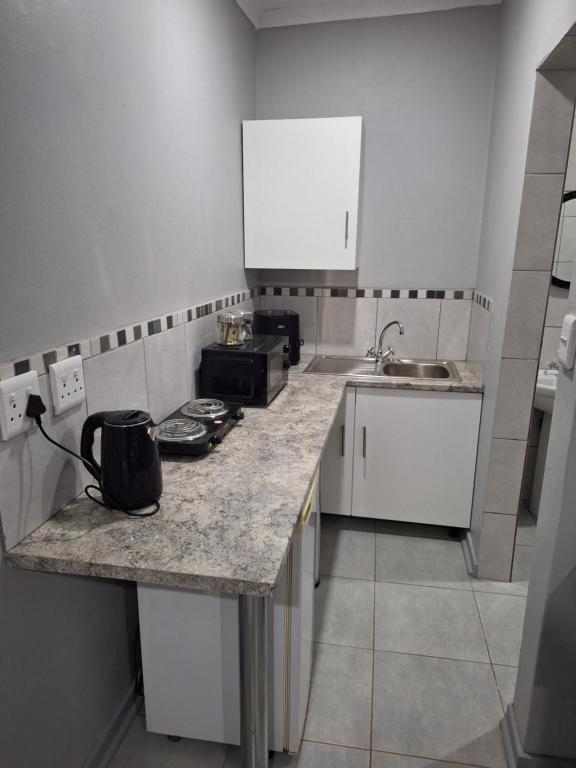 a small kitchen with a counter and a sink at Ivy Roots Guest House in Mokopane