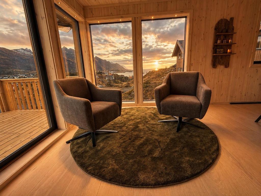 two chairs sitting in a room with a large window at Chalet Glåpen in Moskenes