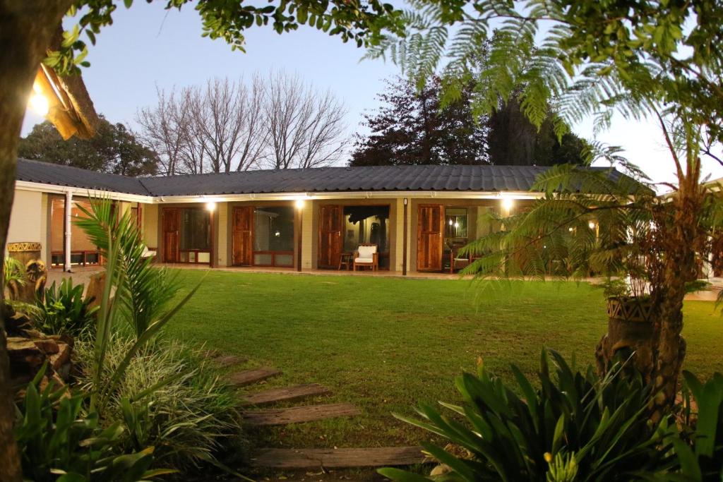a house with a green lawn in front of it at Mountain Dew Guest House in George