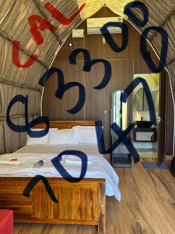a bedroom with a bed with writing on the wall at Riva farmstay in Mayyanād