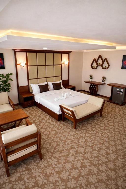 a large hotel room with a large bed and a tv at Kinyuki Country Hotel in Nanyuki
