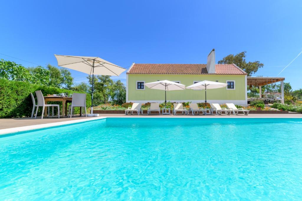 a villa with a swimming pool and a house at Celestial Melides Country House in Melides