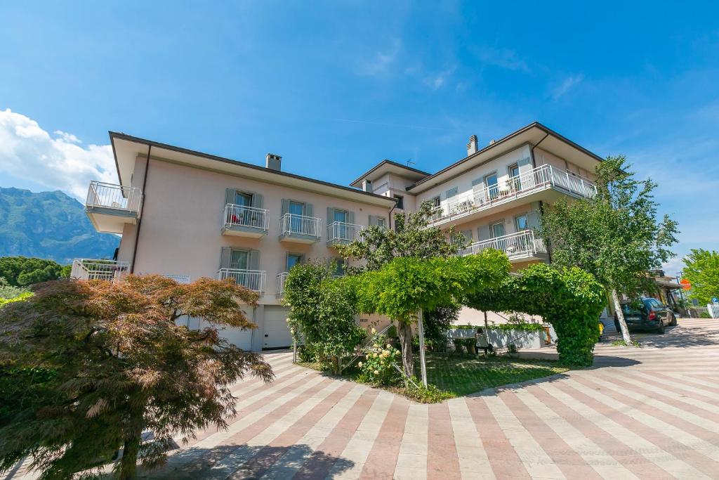 a large building with trees in front of it at Casa al Cor Apartments in Nago-Torbole
