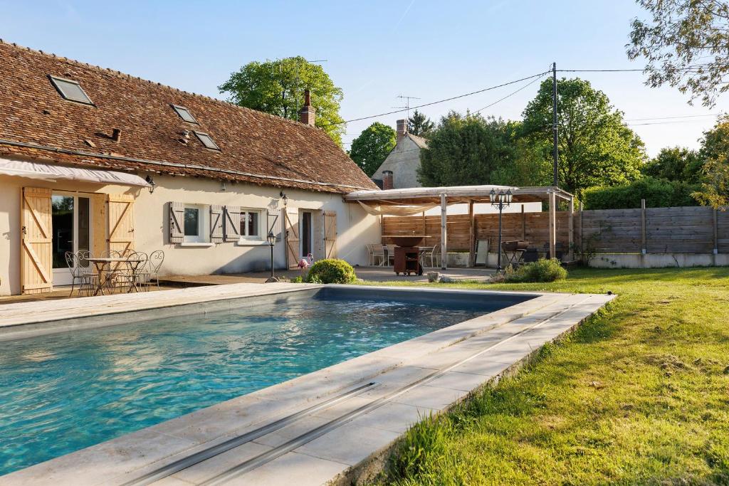 a swimming pool in the backyard of a house at Longère Pierre De Ronsard piscine in Rilly-sur-Loire