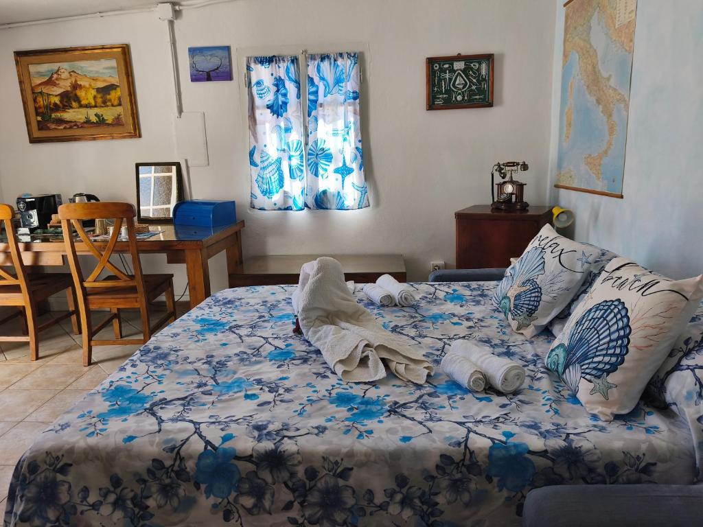 a bedroom with a bed with blue and white sheets at Indigo Moon in Quartu SantʼElena