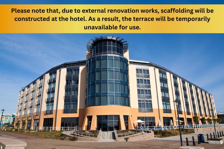 a large office building with a sign that reads please note that due to external at Radisson Blu Waterfront Hotel, Jersey in Saint Helier Jersey