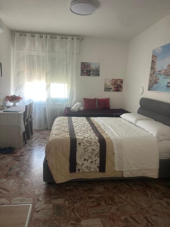 a bedroom with a large bed and a table at stazione Lina house in Mestre