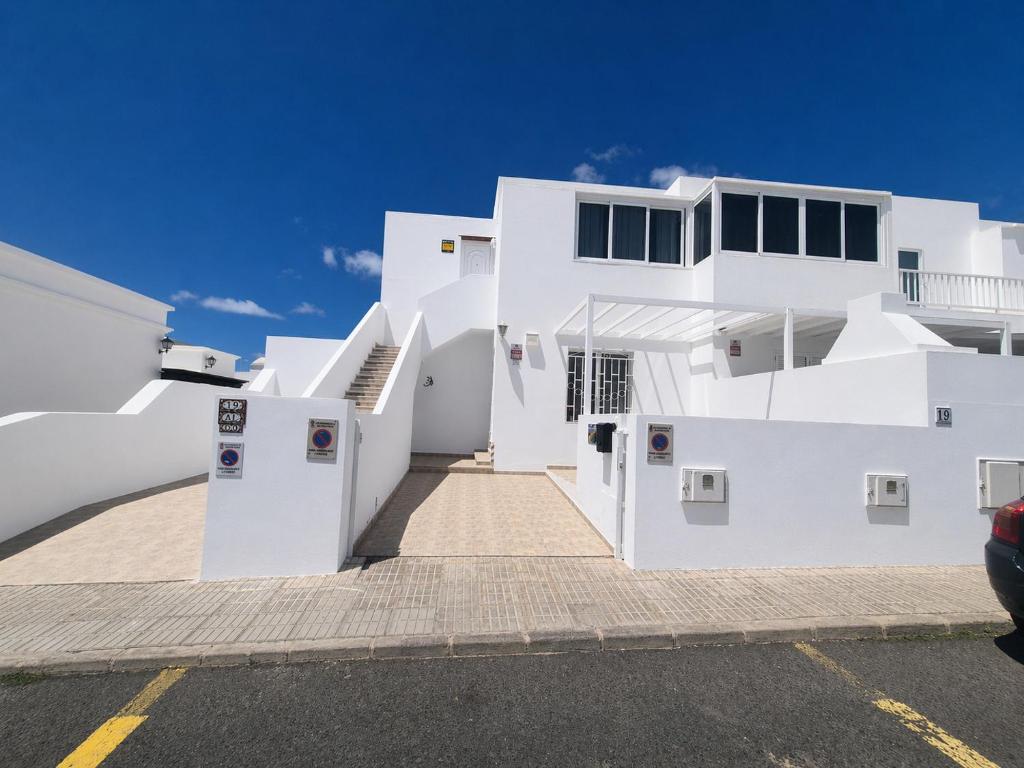 a white house with a parking lot at Casa Donna in Playa Honda