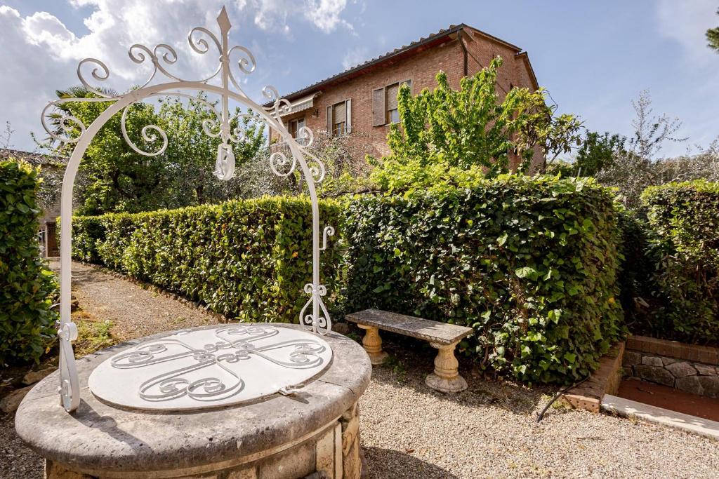 a garden with a stone table and a bench at Tuscan Sunrise Home in Monteriggioni