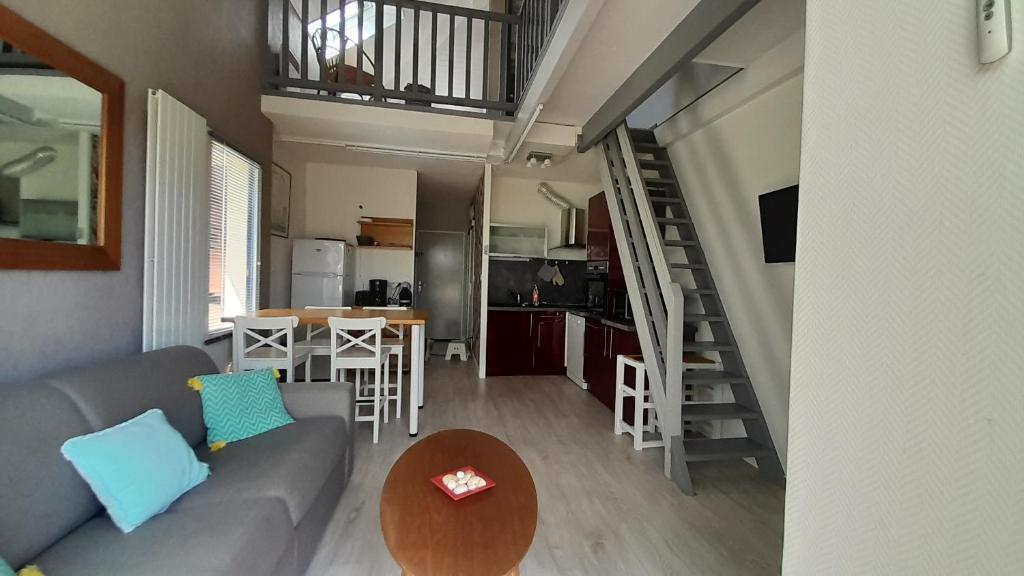 a living room and kitchen with a couch and a table at T2 en duplex spacieux et central in Andernos-les-Bains