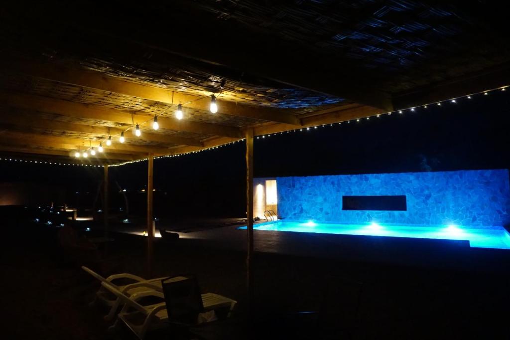 ein Raum mit einer Bühne, die mit blauen Lichtern beleuchtet ist in der Unterkunft Hotel Pirwa in San Pedro de Atacama