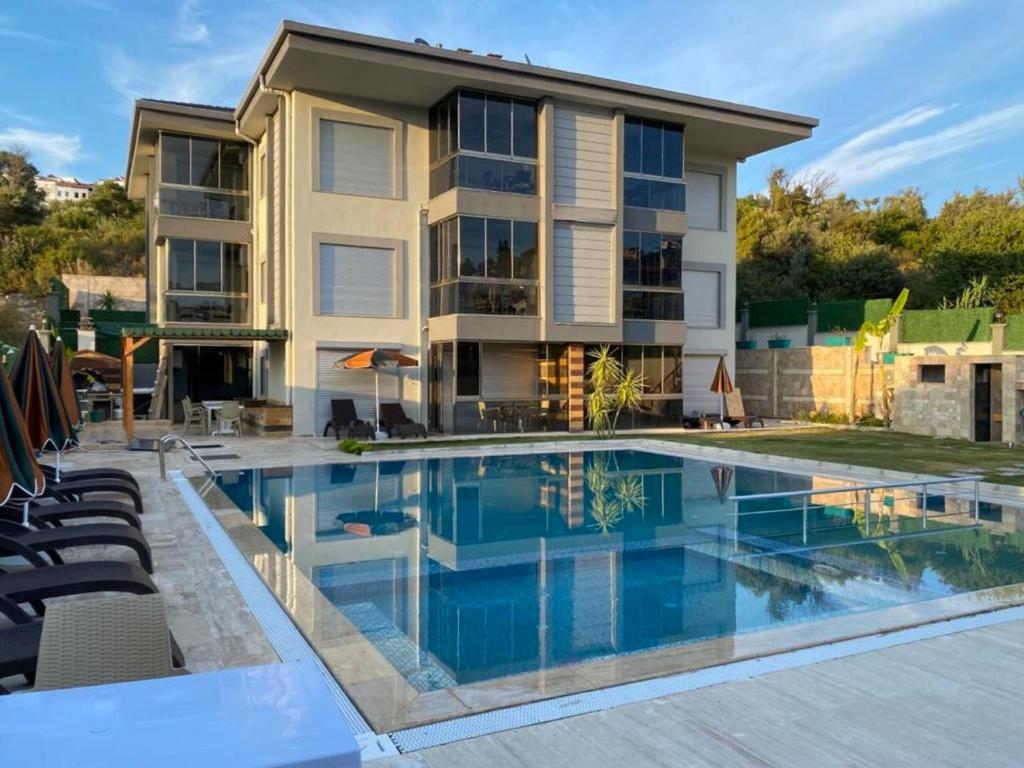 a house with a swimming pool in front of a house at Easy Stay Mia Suites in Aydın