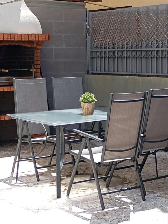 a table and chairs with a potted plant on it at Villa Frescura do Mar by Casas de Setúbal in Setúbal