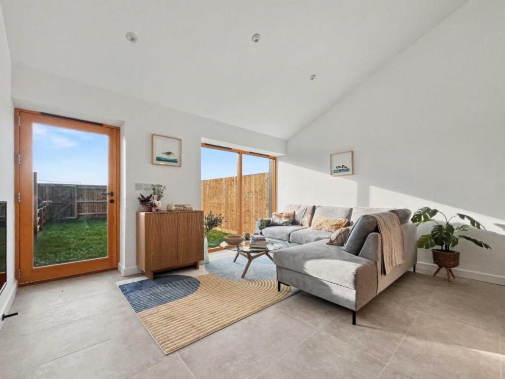a living room with a couch and a television at Damson Barn in Bluntisham