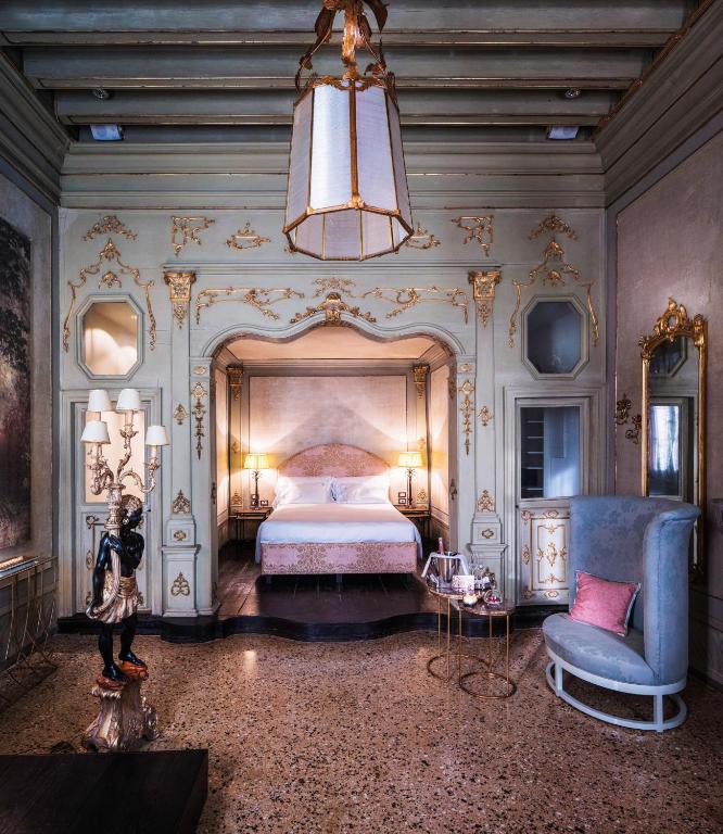 una camera da letto con un letto e un lampadario di Hotel Heureka a Venezia