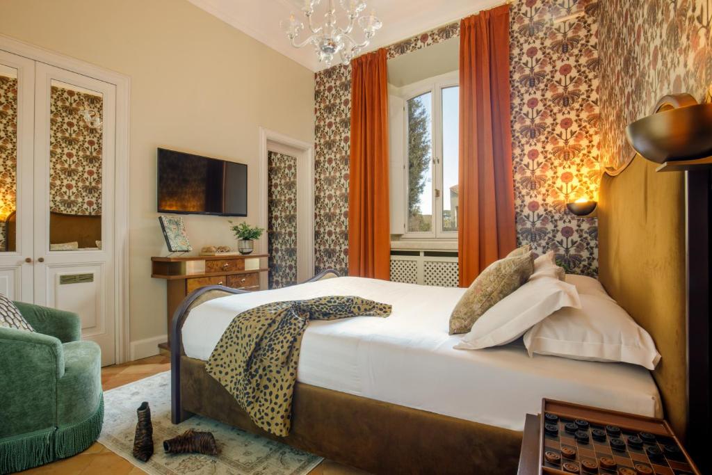 a bedroom with a large bed and a green chair at Hotel Parrasio in Rome