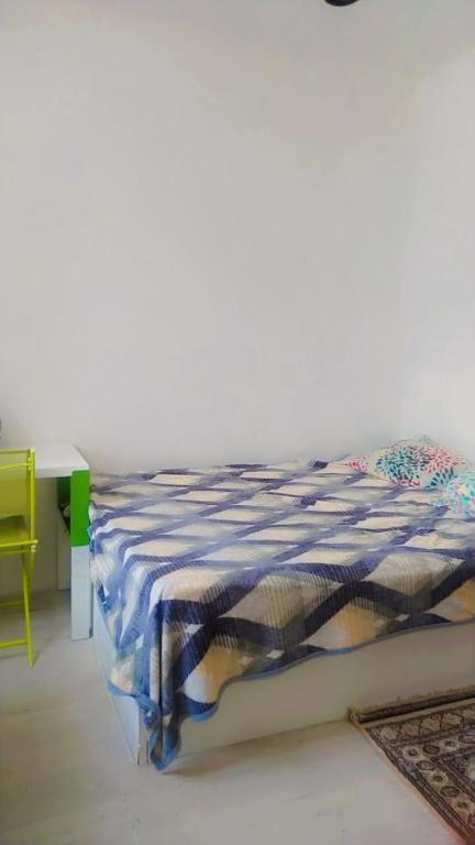 a bed in a room with a table and a bedspread at Hasparren in Hasparren