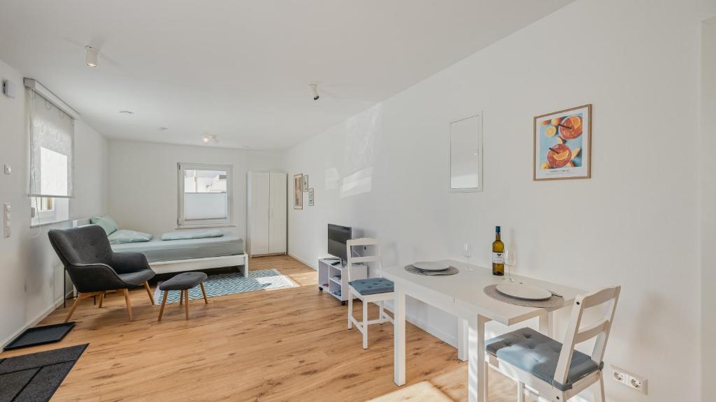 a white living room with a table and chairs at Apartment am Fuchseck in Schorndorf