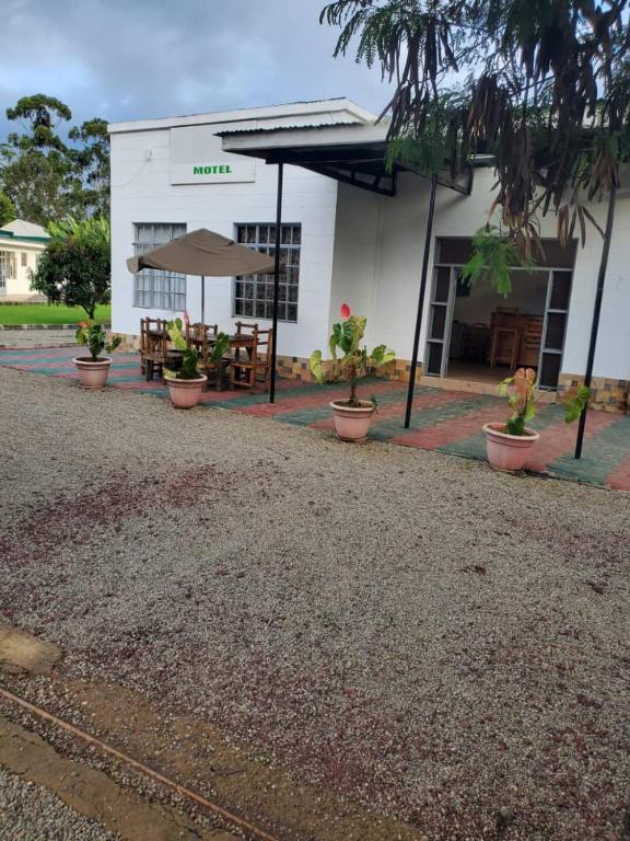 a building with a table and umbrella in front of it at Darajani Motel in Sanya Juu