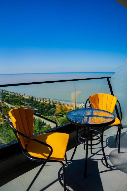 a table and chairs on a balcony with a view at Solis Residence Aparthotel in Batumi