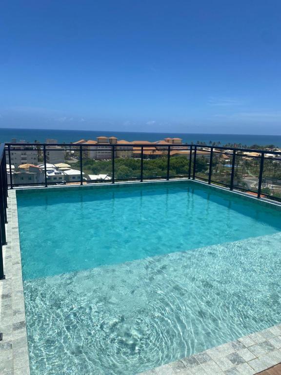 a swimming pool with a view of the ocean at Full Studio in Stella Maris in Salvador