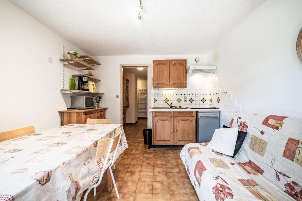 a kitchen with a bed and a couch in a room at Entre Lac Et Montagne in Thollon