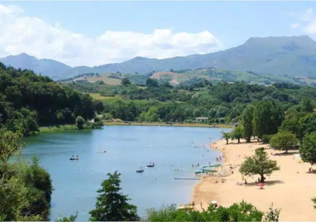 a view of a river with people on a beach at Euskal Herria in Saint-Pée-sur-Nivelle