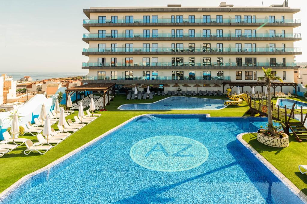 a hotel with a swimming pool and chairs and a building at AZ Appart hotels Saitour in Mazagran