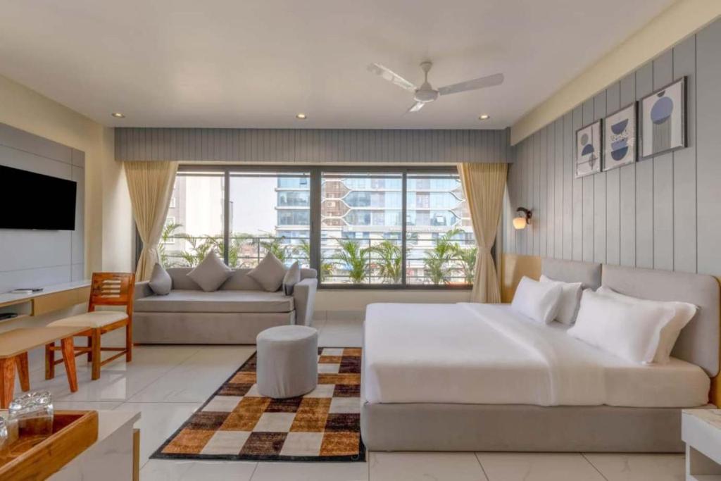 a bedroom with a large bed and a living room at hotel monville akota in Vadodara