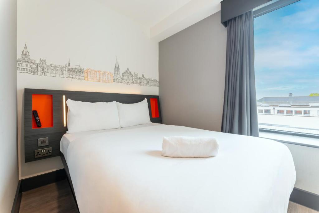 a bedroom with a white bed and a window at easyHotel Oxford in Oxford