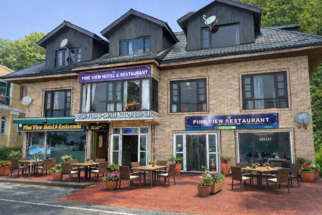 a restaurant with tables and chairs in front of a building at Pine view in Gulmarg