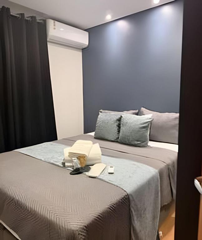 a bedroom with two beds and a blue wall at Safiras Premium | Seu conforto em Cuiabá in Cuiabá
