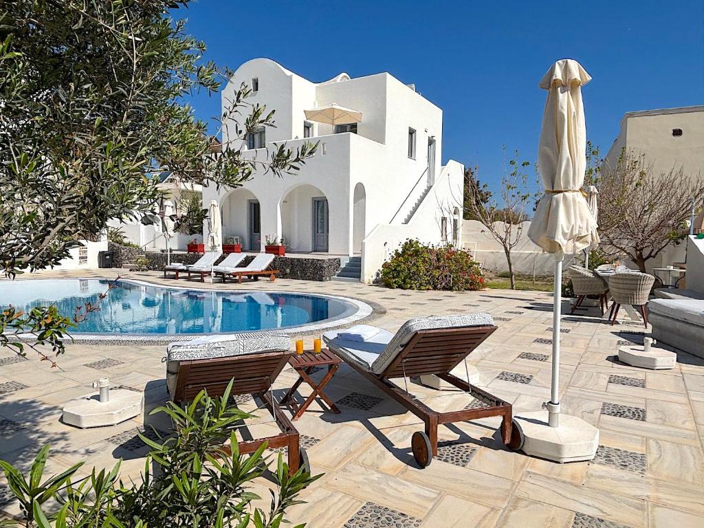 a house with a pool and two chairs and an umbrella at Villa Thea in Kamari