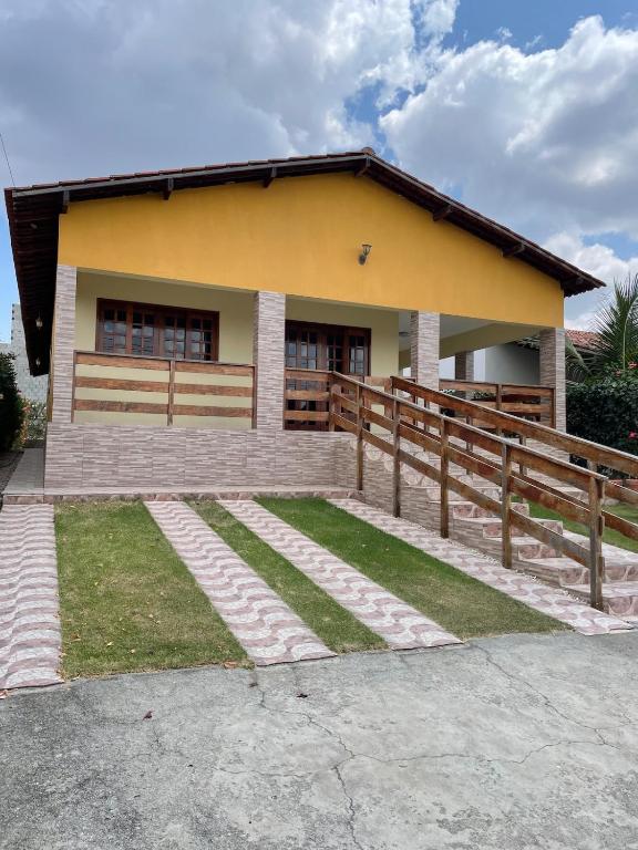 a small yellow house with a wooden fence at Casa aconchegante em Bezerros- REI DAVID CONDOMÍNIO CLUBE in Bezerros