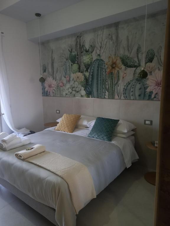 a bedroom with a large bed with a painting on the wall at Glamonia rooms in Campobasso