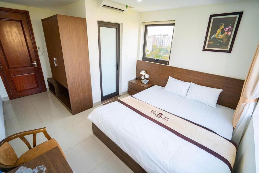 a bedroom with a large bed with a wooden headboard at Thăng Long II hotel FLC in Lôc Hải