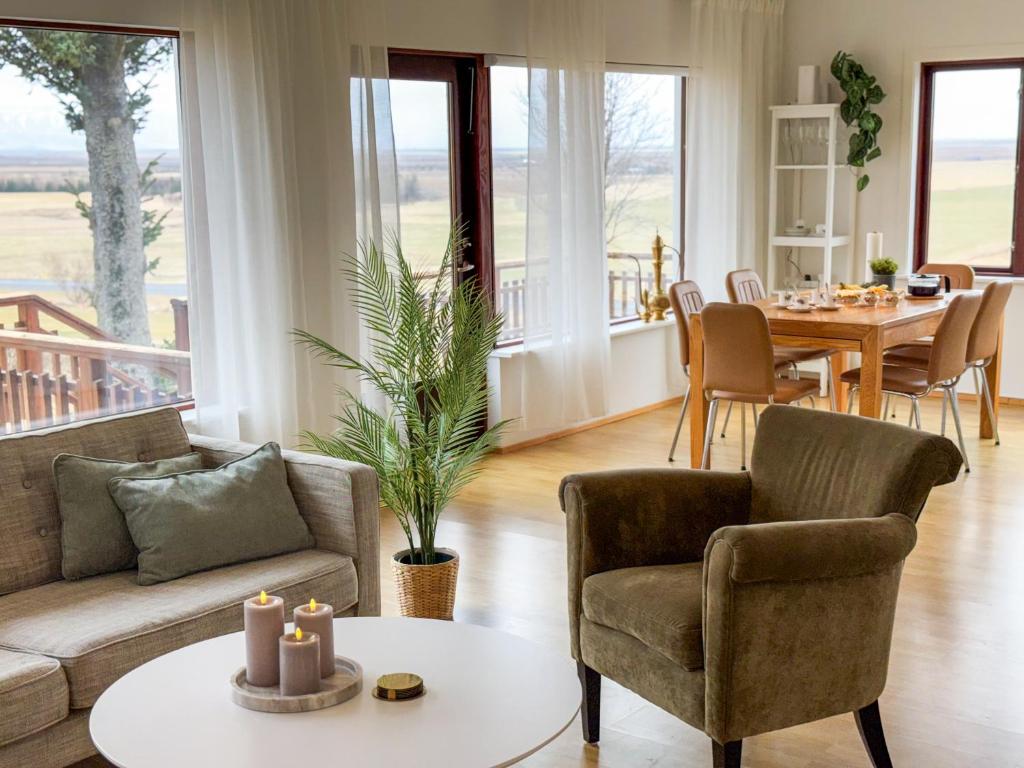 a living room with a couch and chairs and a table at Fagrahlid Guesthouse in Hvolsvöllur