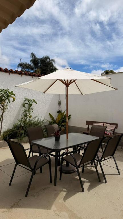 a table and chairs with an umbrella on a patio at Casinha Vale do Sol in Nova Lima
