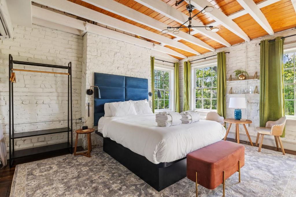 a large bedroom with a large bed and windows at 4th Floor Queen Suite Boutique hotel in Savannah