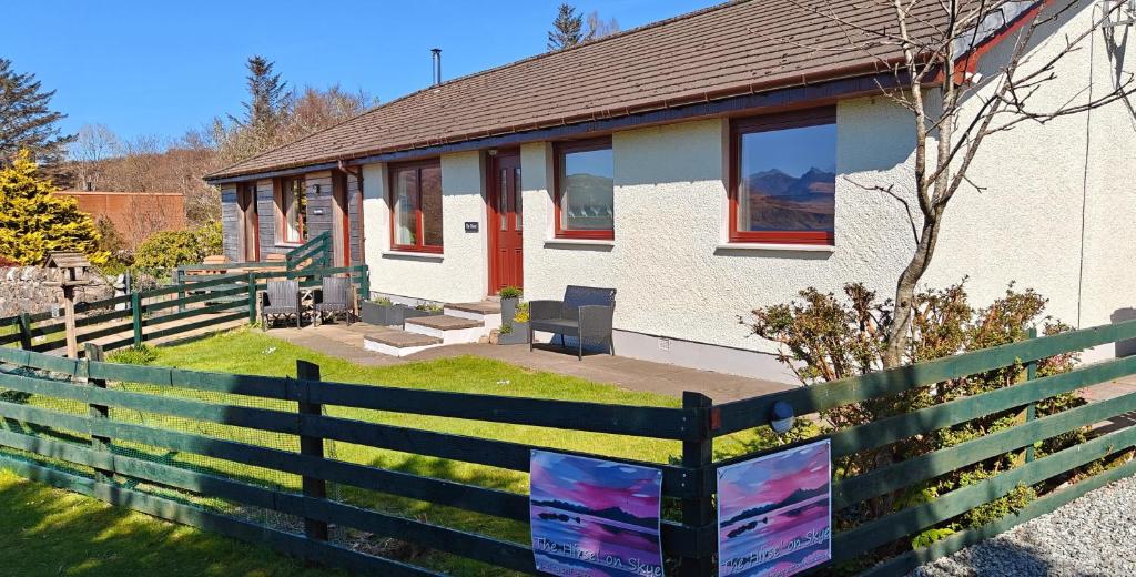 a house with a fence in front of it at The Hirsel on Skye in Ord