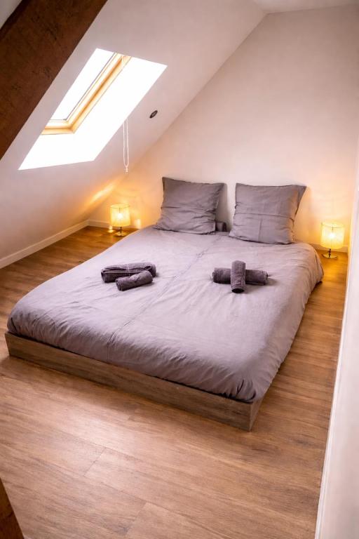 a bedroom with a large bed with two pillows on it at Au Carnot in Douai