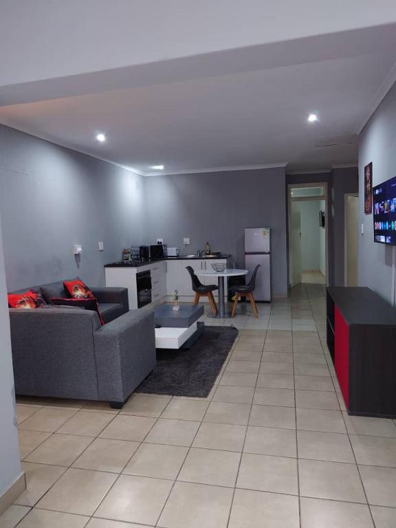 a living room with a couch and a table at Fullmoon Homes 9A in Edenvale