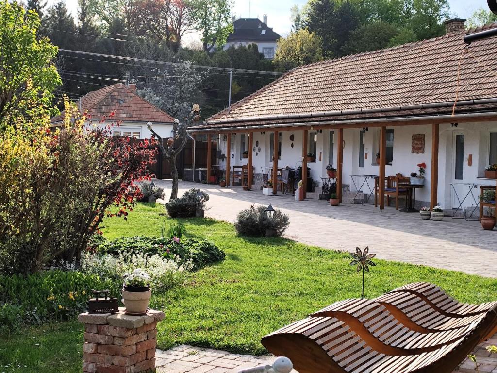 a bench in a yard next to a building at Bóbita Apartmanház in Szilvásvárad