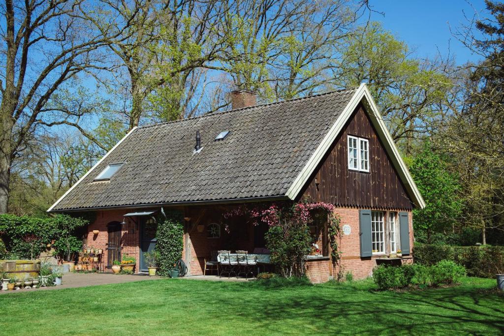 a red brick house with a black roof at De Fazant in Laren