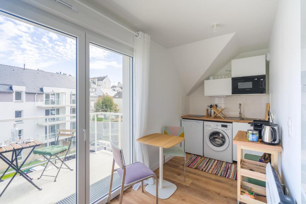 a kitchen with a balcony with a table and chairs at Studio de la Plage des Dames - À 50 m de la plage in Douarnenez