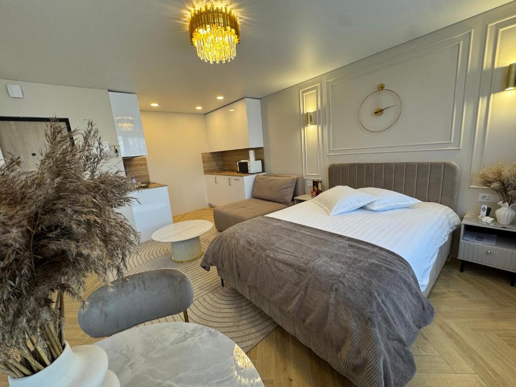 a bedroom with a bed and a couch and a clock at Baltic Avenue in Klaipėda