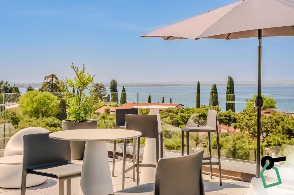 a patio with a table and chairs and an umbrella at Hotiday Lazise Garda in Lazise