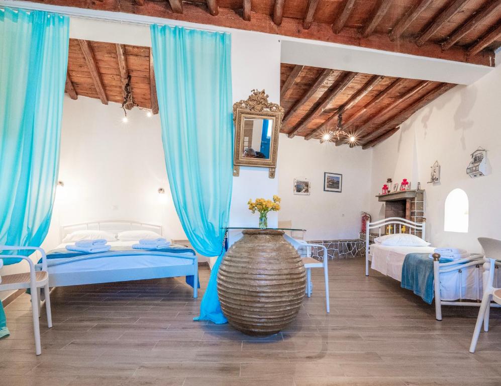 a bedroom with two beds and blue curtains at Alexandra House in Kimolos